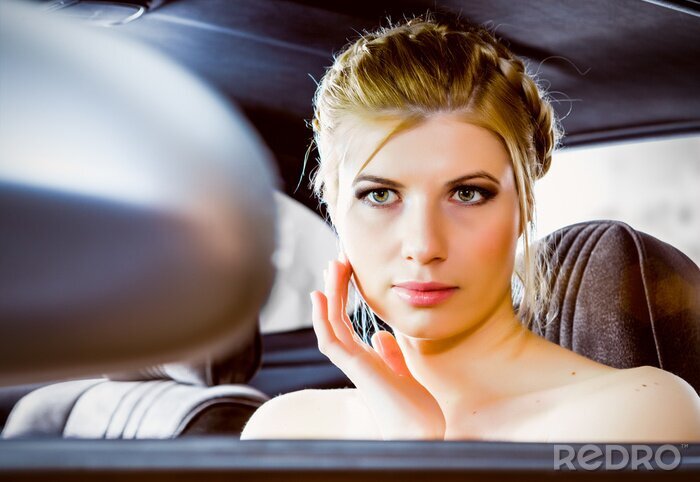 Fototapete junge Frau, die im Rückspiegel Auto