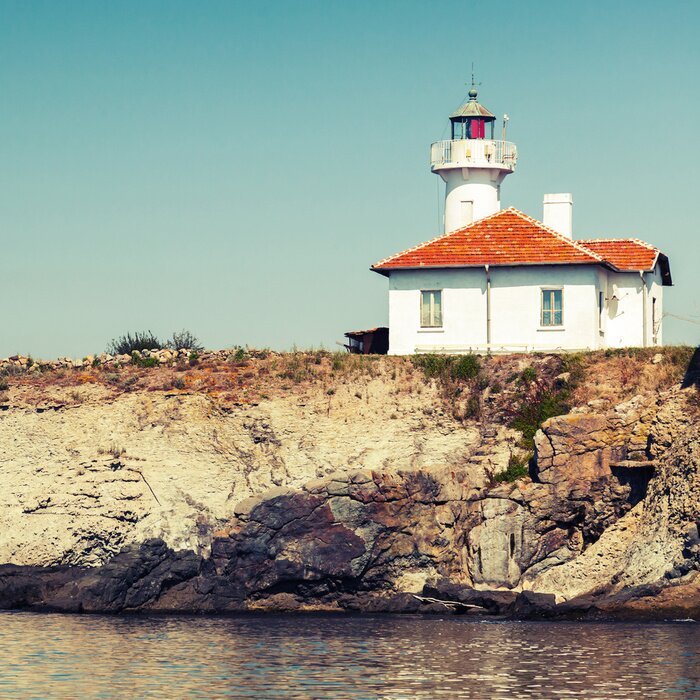 Fototapete Leuchtturm bei weißem Häuschen