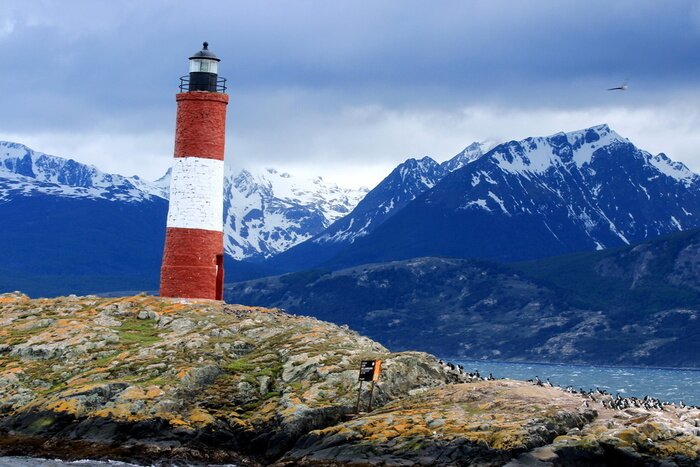 Fototapete Leuchtturm mit Gebirgen im Hintegrund