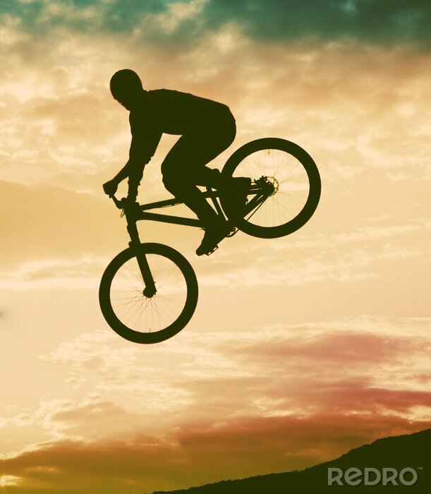 Fototapete Mann mit einem Fahrrad in der Luft