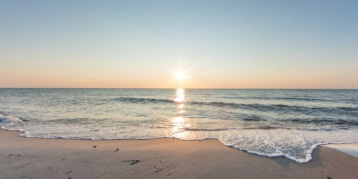 Fototapete Meer und Strand im Schein der untergehenden Sonne