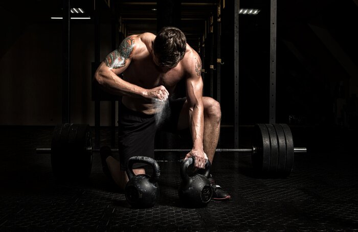 Fototapete Muskelbepackter Mann, der Gewichte hebt