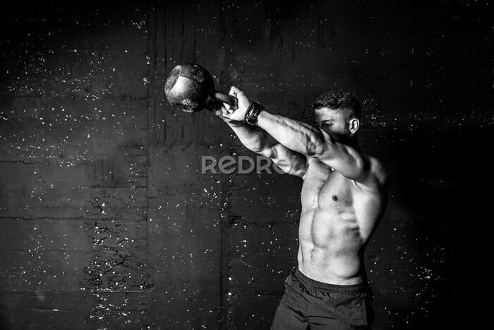 Fototapete Muskulöser Mann beim Training mit einer Kettlebell