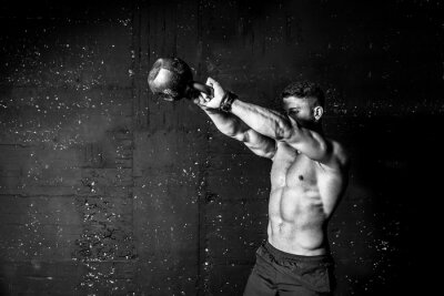 Fototapete Muskulöser Mann beim Training mit einer Kettlebell
