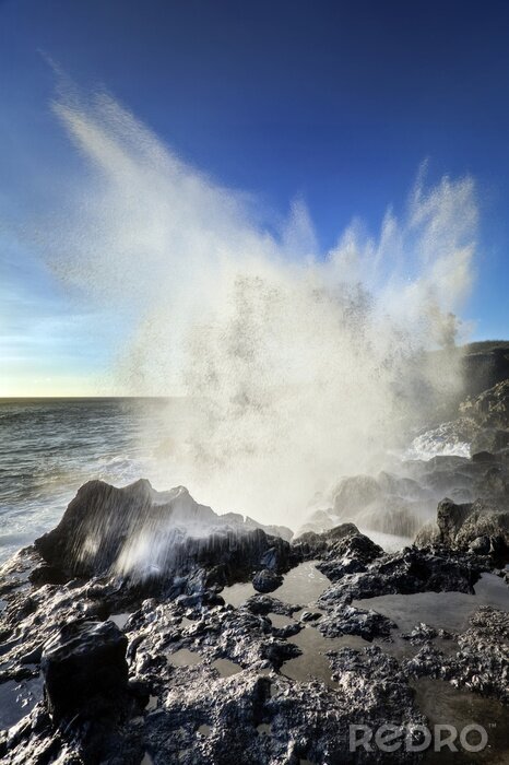 Fototapete Natur als Welle, die sich an den Felsen bricht