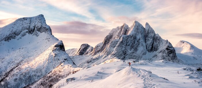 Fototapete Panorama schneebedeckter Berge mit einem Mann auf dem Gipfel