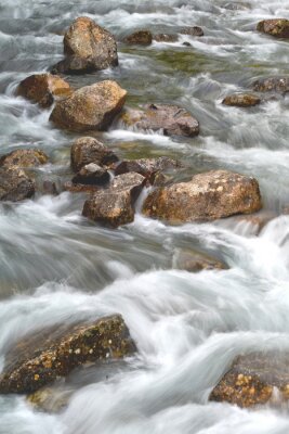 Fototapete Reißender Fluss mit Steinen