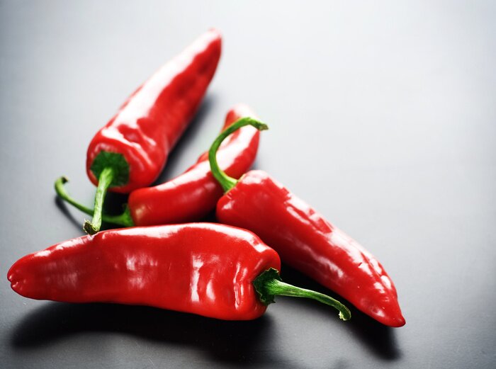 Fototapete Rote Paprikaschoten auf dunklem Hintergrund