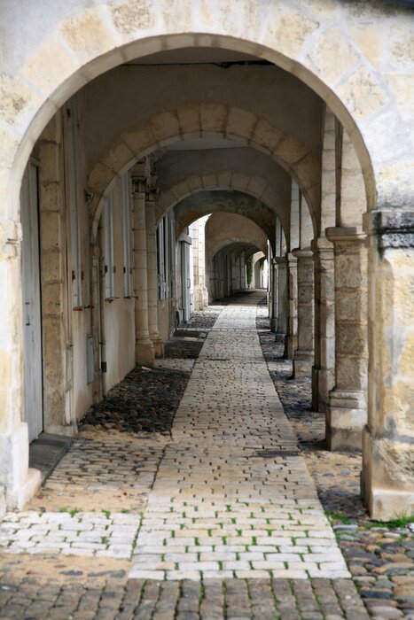 Fototapete Säulen bei gepflasterter Gasse