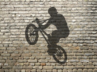 Fototapete Schatten des Radfahrers an der Mauer