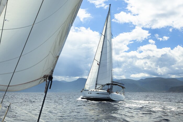 Fototapete Segelboote und bergiges Festland