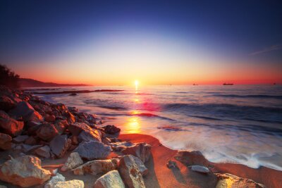 Sonnenaufgang und Felsen am Meer