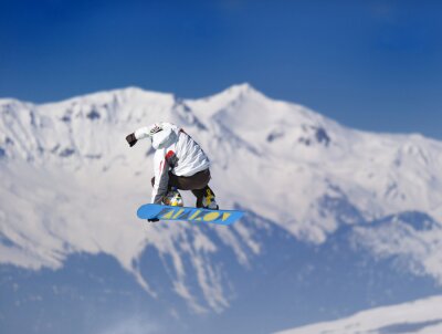 Springender Snowboarder vor dem Hintergrund der Berge