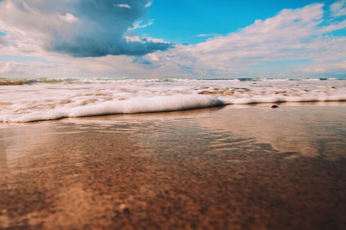 Fototapete Strand und geschäumte Welle