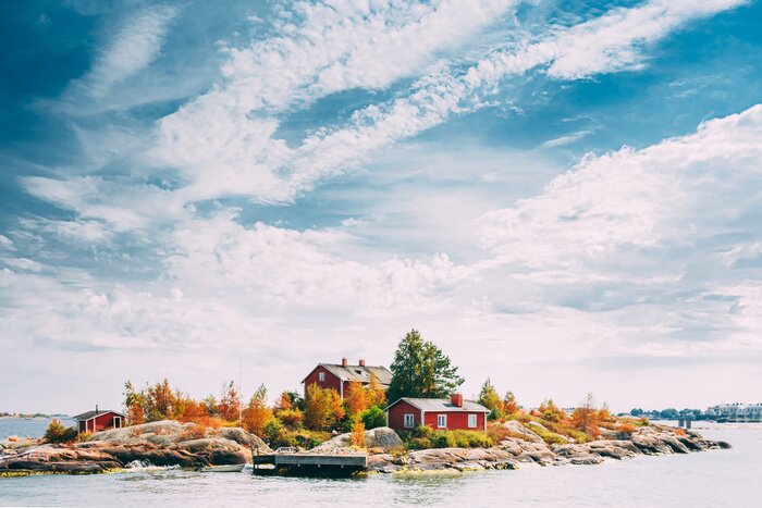 Fototapete Suomi Or Finland. Beautiful Red Finnish Wooden Log Cabin House On Rocky Island Coast In Summer Sunny Evening. Lake Or River Landscape. Tiny Rocky Island Near Helsinki, Finland