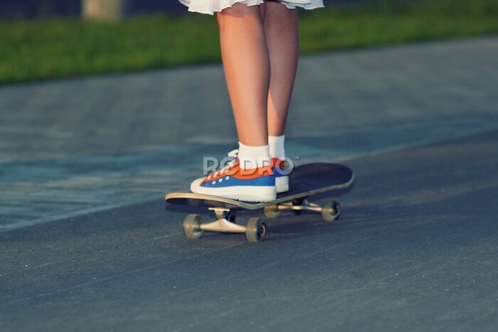 Fototapete Teenager Beine in Turnschuhen mit Skateboard bei Sonnenuntergang.