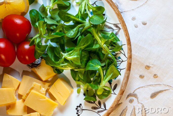 Fototapete Teller mit grünem Gemüse und Käse