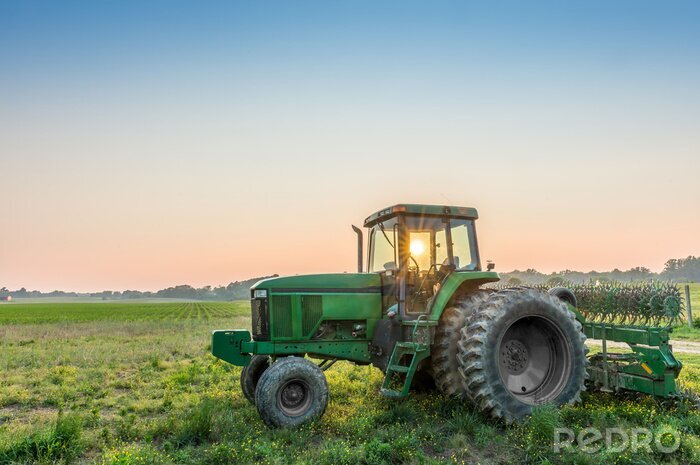 Fototapete Traktor im Hintergrund einer Feldlandschaft