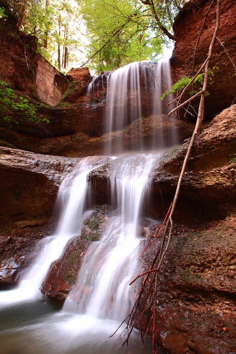 Fototapete Wasserfall und rote Felsen