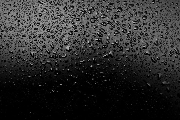 Fototapete Wassertropfen auf schwarzer Oberfläche