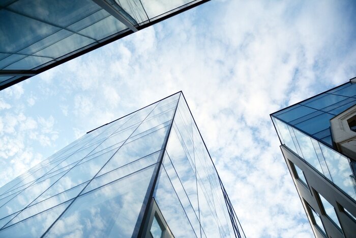 Fototapete Wolkenkratzer mit Wolken im Hintergrund
