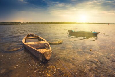 Zwei Boote am Fluss bei Sonnenuntergang