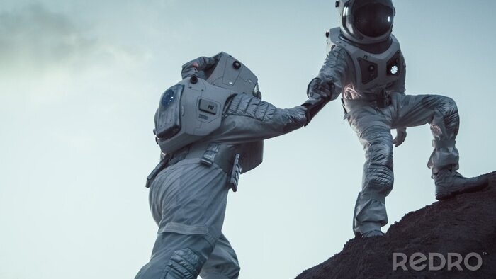 Fototapete Zwei sich miteinander helfende Astronauten