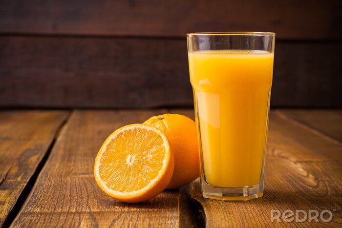 Poster Aufgeschnittene Orange neben einem Glas Saft