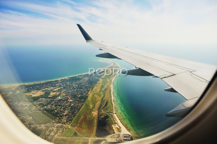 Poster Blick aus dem Flugzeugfenster auf die Halbinsel und den Flügel.