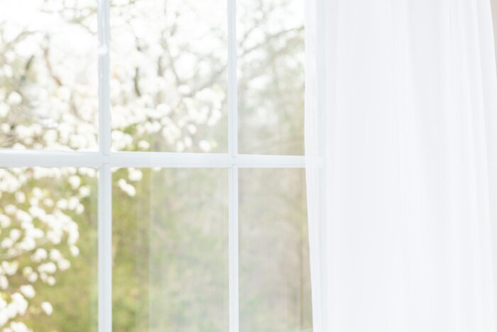 Poster Blick aus einem mit einem Vorhang bedeckten Fenster