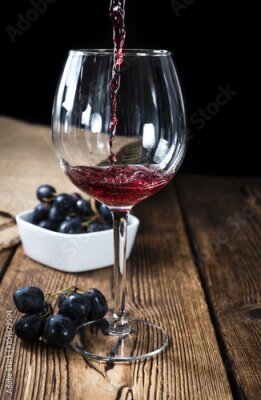 Poster Ein Glas Rotwein auf einem Holztisch