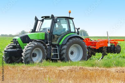 Poster Ein grüner Traktor bei der Arbeit auf einem Feld