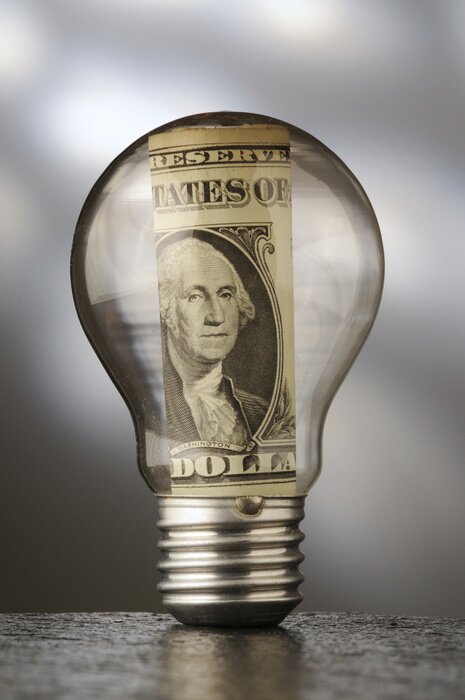 Poster Eine aufgerollte Dollar-Geldschein in einer Glühbirne