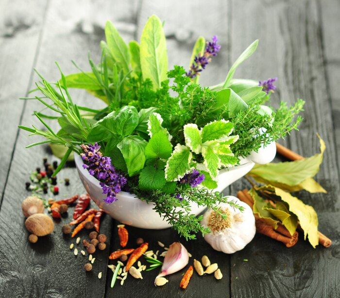 Poster Eine Mischung aus frischen Kräutern und Gewürzen auf einer hölzernen Arbeitsplatte