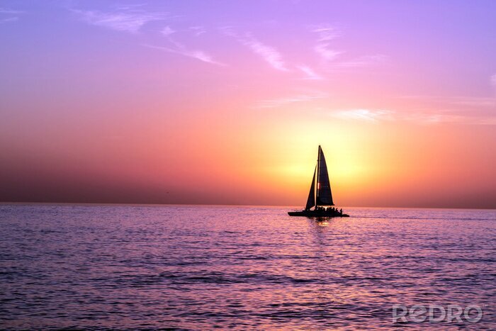 Poster Einsames Segelboot auf dem Hintergrund des Sonnenuntergangs