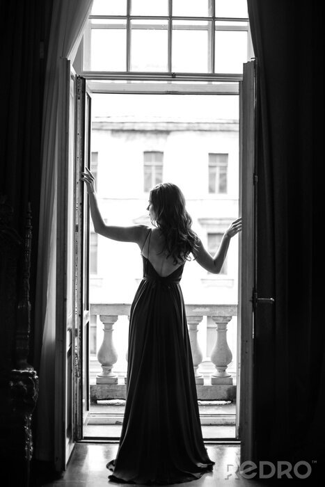 Poster Elegante Frau an der Balkontür