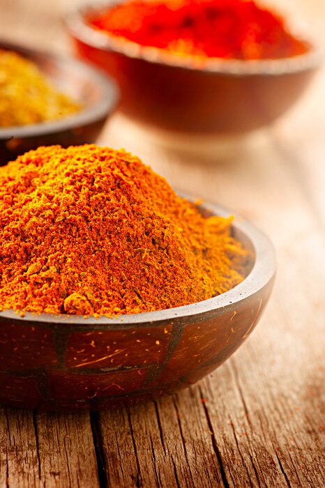 Poster Gewürze in Schalen auf Holztischplatte