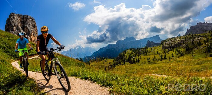 Poster Mann und Frau auf Fahrrädern in den Dolomiten