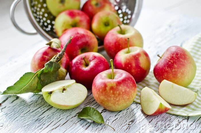 Poster Obst Äpfel auf einer hellen Tischplatte verstreut