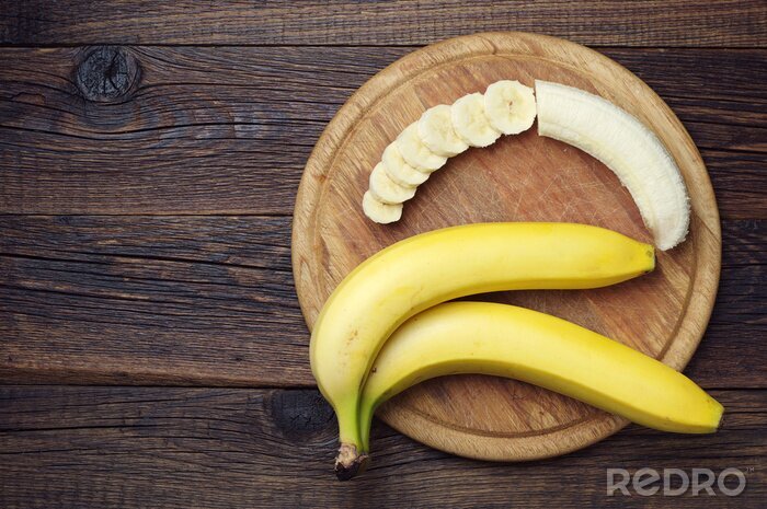 Poster Obst drei Bananen auf Holztablett