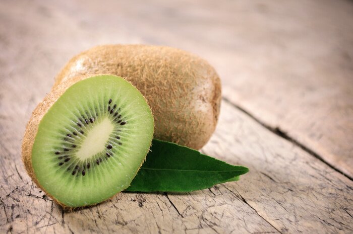 Poster Obst Kiwi auf Holztischplatte platziert