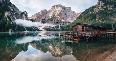 Panoramablick von Braies Lake mit der Hütte und den Booten in den Dolomitbergen und in Seekofel morgens, Sudtirol, Italien