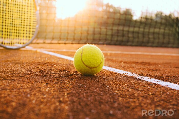 Poster Tennisschläger und Ball auf einem Sandplatz-