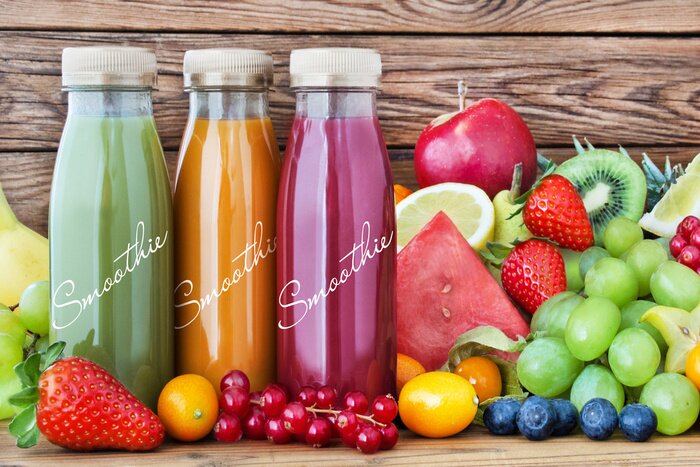 Poster Verschiedenfarbige Smoothies vor dem Hintergrund der Früchte