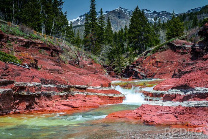 Poster Wasserfall Natur umgeben von roten Felsen