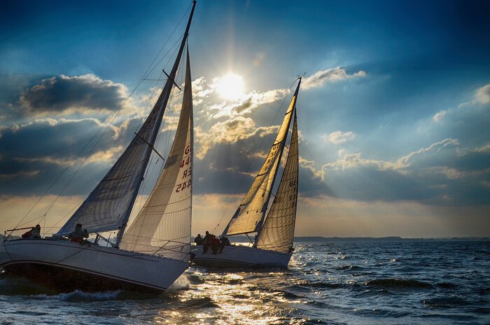 Poster Zwei Segelboote und Sonnenschein hinter den Wolken