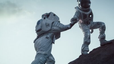 Zwei sich miteinander helfende Astronauten