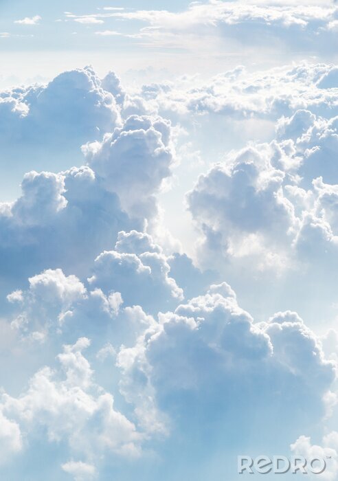 Sticker Blick auf flauschige weiße Wolken vor dem Hintergrund eines blauen Himmels