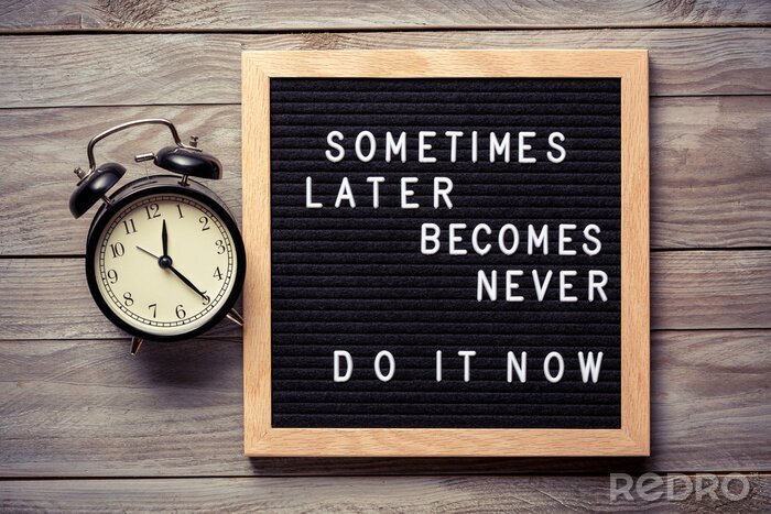 Sticker Inspirational motivational quote Sometimes later becomes never. Do it now words on a letter board on wooden background near vintage alarm clock. Success and motivation concept.