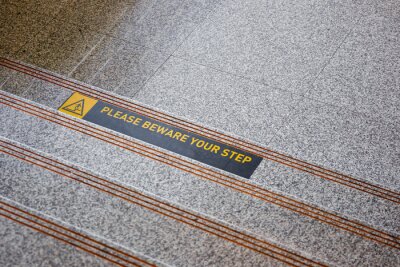 Please beware your step sticker on polished stone floor close up.